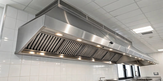 Commercial ventilation hood system in stainless steel with baffle filters and lights.